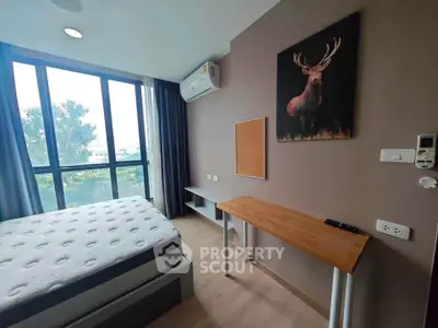 Modern bedroom with large window and stylish decor, featuring a comfortable bed and air conditioning.