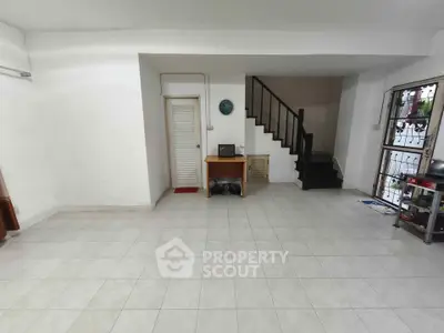 Spacious interior with tiled flooring and staircase, ideal for customization.