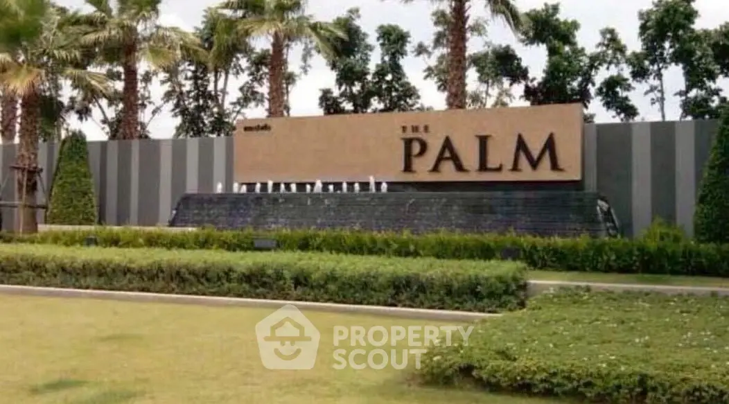 Luxurious entrance of The Palm with lush landscaping and elegant signage.