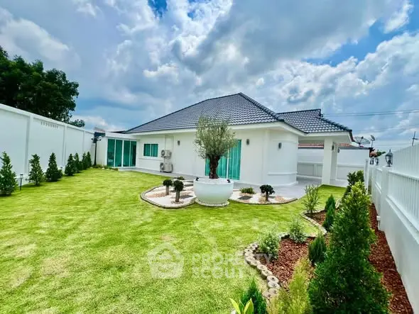 Charming single-story home with lush green garden and modern architecture.