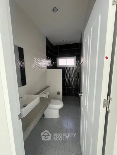 Modern bathroom with sleek fixtures and stylish black and white tile design.