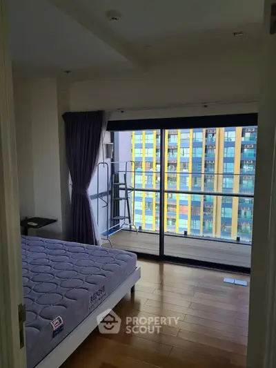 Spacious bedroom with balcony and city view in modern apartment
