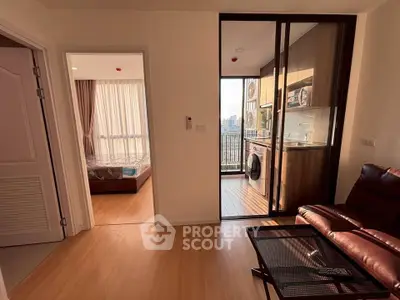 Modern apartment interior with bedroom, living area, and kitchen featuring a washing machine and balcony view.