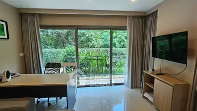 Modern living room with garden view, sleek furniture, and large windows for natural light.