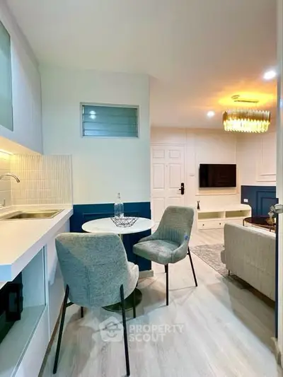 Modern living room with open kitchen and stylish decor in a cozy apartment.