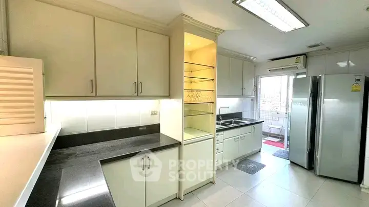 Spacious modern kitchen with sleek cabinetry and stainless steel appliances