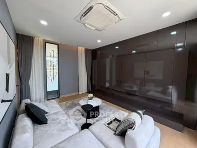 Modern living room with sleek design, large sectional sofa, and built-in entertainment unit.