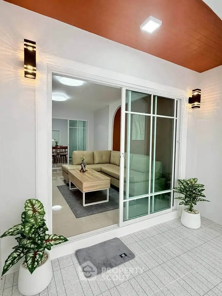 Modern living room with sliding glass doors and stylish lighting, featuring a cozy sofa and elegant decor.