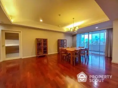 Spacious dining area with elegant wooden flooring and city view balcony.