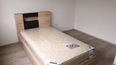 Minimalist bedroom with wooden bed frame and new mattress