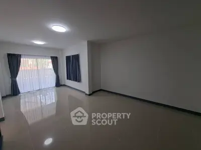 Spacious empty room with large windows and glossy tiled floor