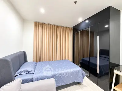 Modern bedroom with sleek black wardrobe and cozy bed in stylish apartment.