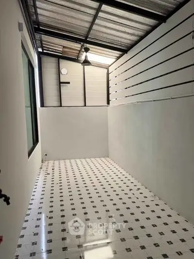 Spacious tiled area with modern roof and natural light, perfect for versatile use.