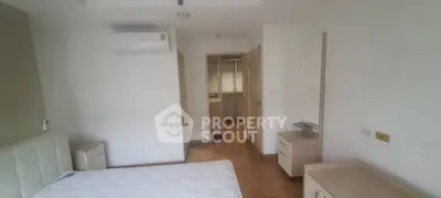 Spacious bedroom with modern furnishings and air conditioning unit