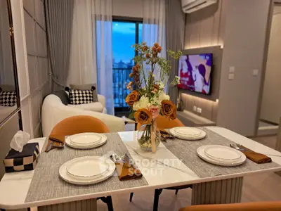 Stylish modern living room with elegant dining setup and city view balcony.