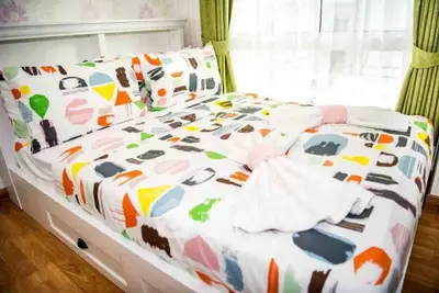 Bright and colorful bedroom with modern decor and large window for natural light.