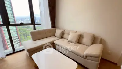 Modern living room with cozy beige sofa and stunning city view through large windows.