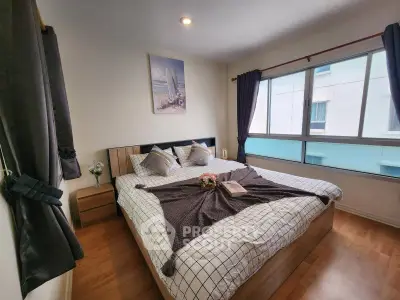 Cozy bedroom with large window and stylish decor in modern apartment