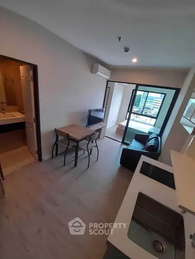 Modern apartment interior with open layout, featuring a cozy living area and kitchen, perfect for urban living.