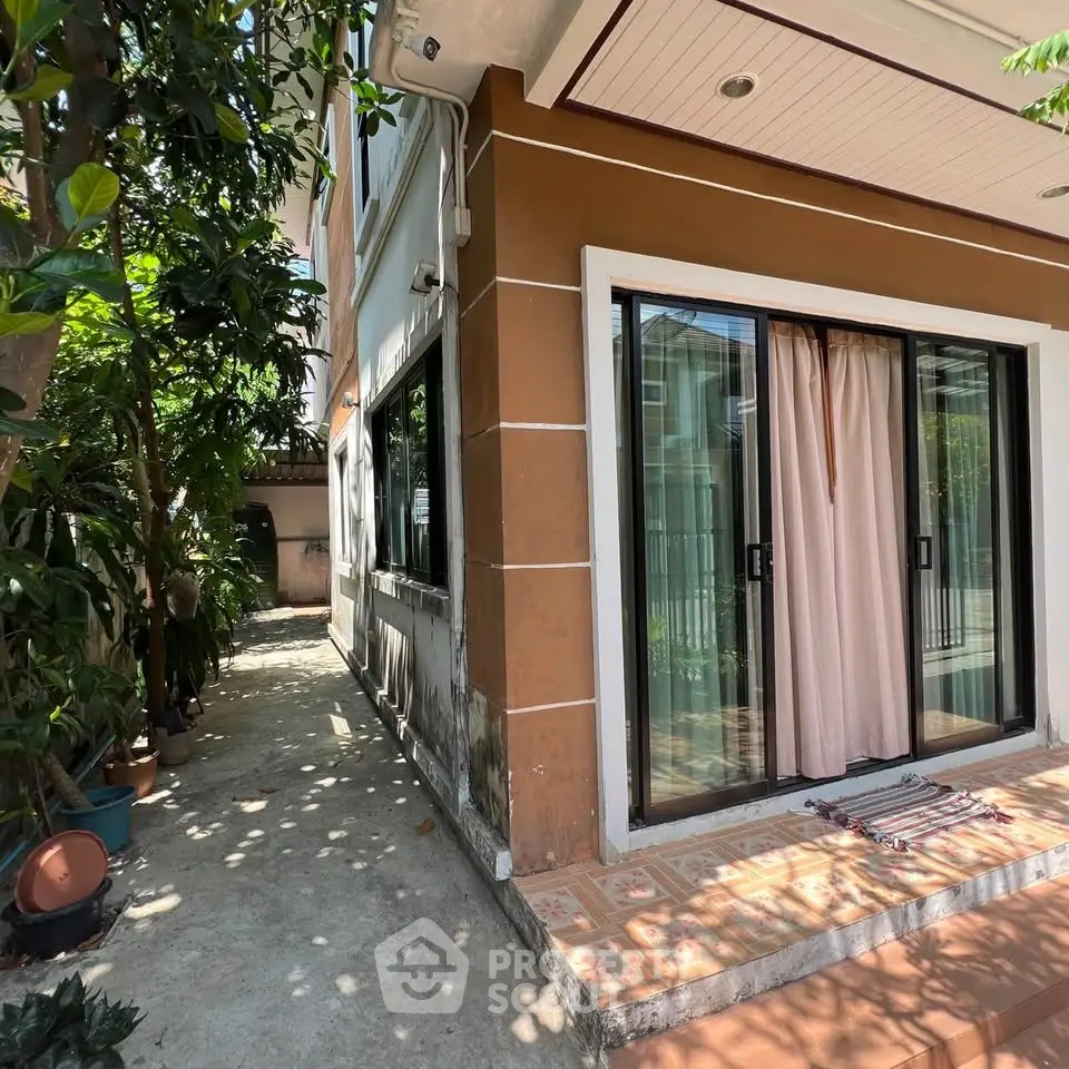 Charming residential property with sliding glass doors and lush greenery, perfect for serene living.
