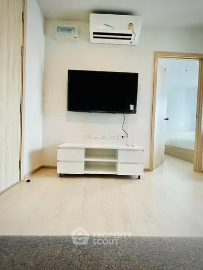 Modern living room with wall-mounted TV and air conditioning in a stylish apartment.