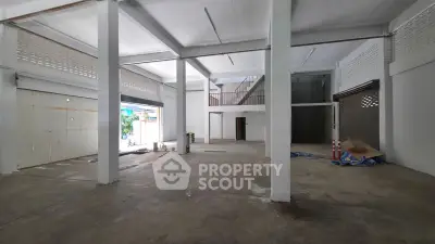 Spacious industrial-style open space with high ceilings and mezzanine, ideal for creative studio or workshop.