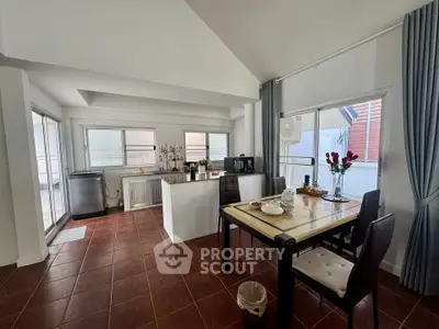 Spacious dining area with modern kitchen and large windows in a stylish apartment.