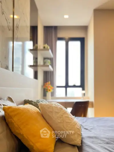 Modern bedroom with cozy pillows and natural light from large window