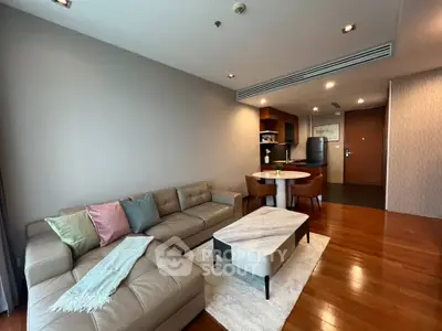 Modern living room with open kitchen, stylish decor, and cozy seating area.