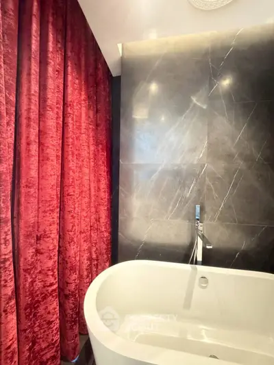 Luxurious bathroom with elegant bathtub and rich red velvet curtains