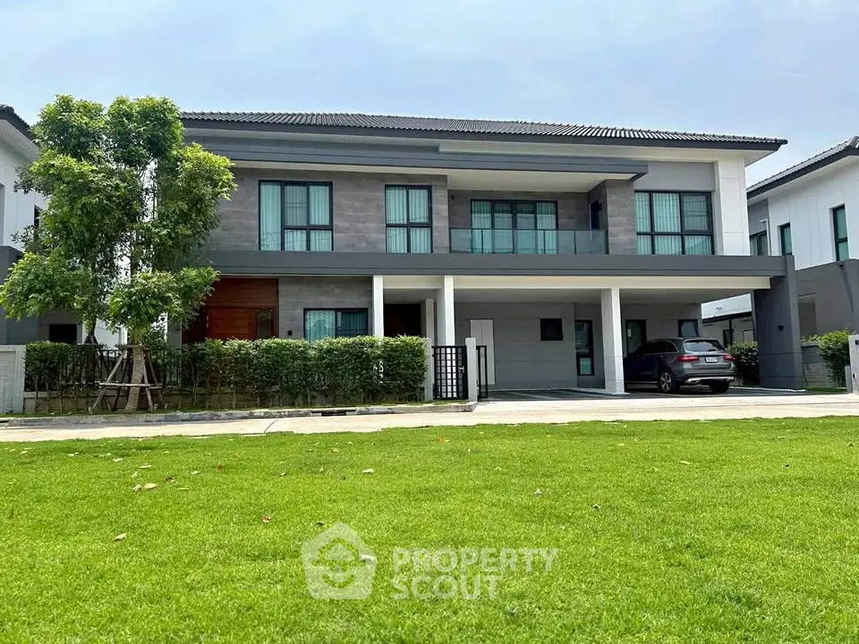 Modern two-story house with spacious lawn and sleek design in a serene neighborhood.