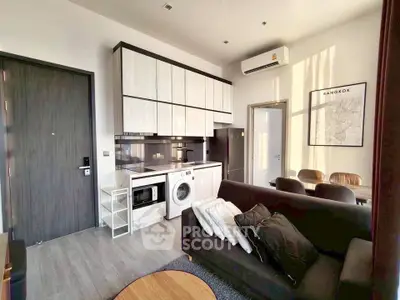Modern living room with integrated kitchen and washing machine in stylish apartment.