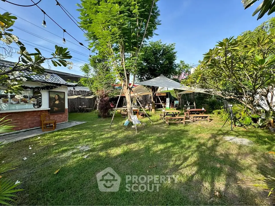 Charming garden with lush greenery and outdoor seating, perfect for relaxation.