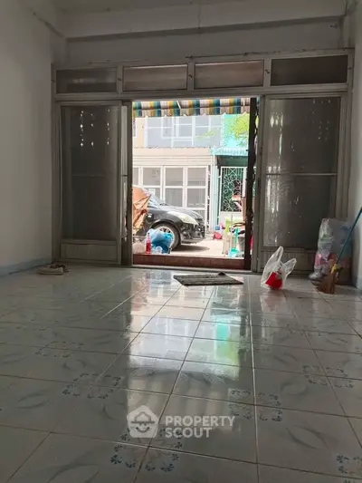 Spacious tiled room with large windows and street view, ideal for versatile use.
