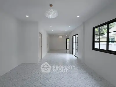 Spacious open-plan living area with modern lighting and large windows