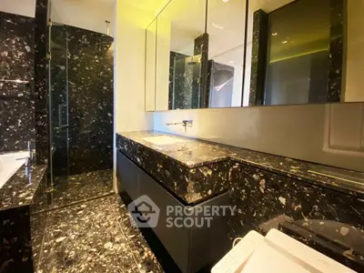Luxurious modern bathroom with sleek black marble design and elegant fixtures.