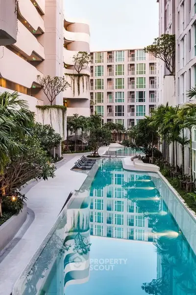 Luxurious apartment complex with stunning pool and lush greenery