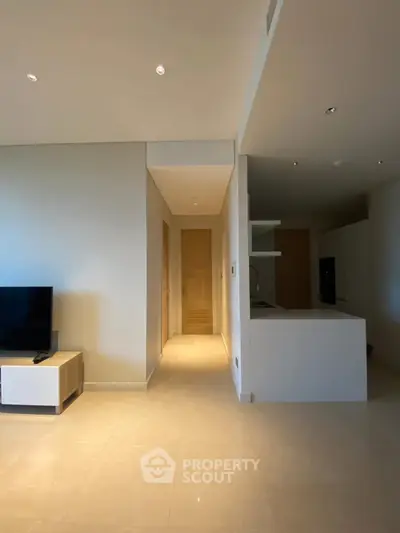 Modern living room with sleek design and open layout, featuring a TV and stylish furniture.