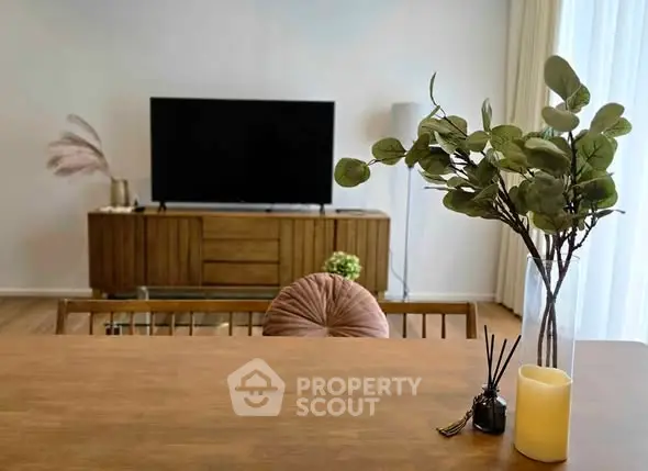 Stylish living room with modern decor and large TV, perfect for relaxation and entertainment.