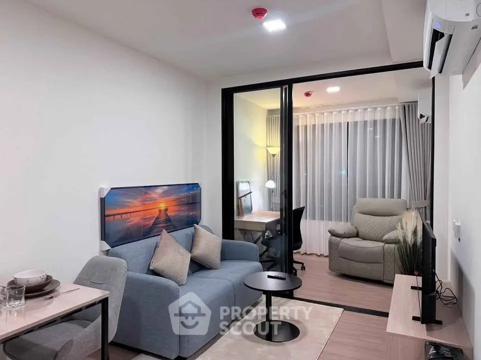 Modern living room with cozy seating and study area in a stylish apartment.