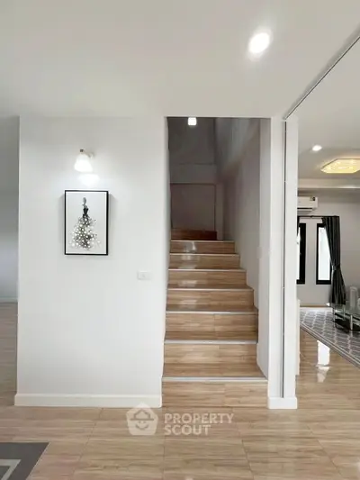 Modern interior with wooden staircase and stylish decor in a bright living space.