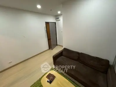 Cozy living room with brown sofa and wooden flooring, perfect for relaxation.
