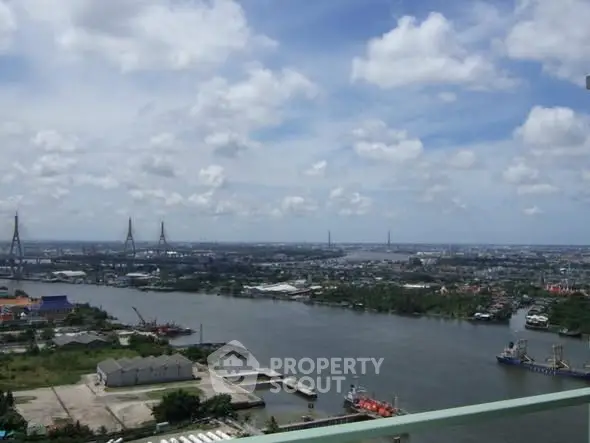 Stunning river view from high-rise balcony with cityscape and bridge in the background.