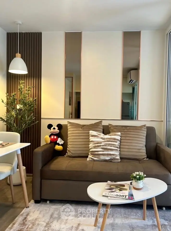 Stylish living room with cozy sofa, modern decor, and dining area in a contemporary apartment.