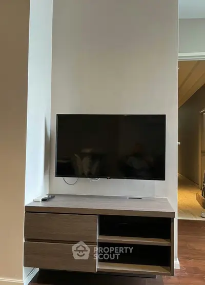 Modern living room with sleek TV setup and stylish wooden cabinet.