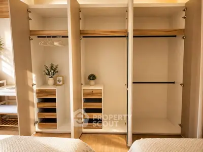 Spacious bedroom with open wardrobes and natural light, perfect for organized living.