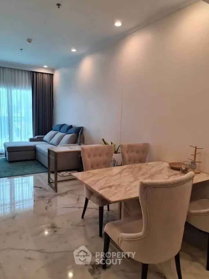 Elegant living room with marble flooring and stylish dining area in modern apartment.