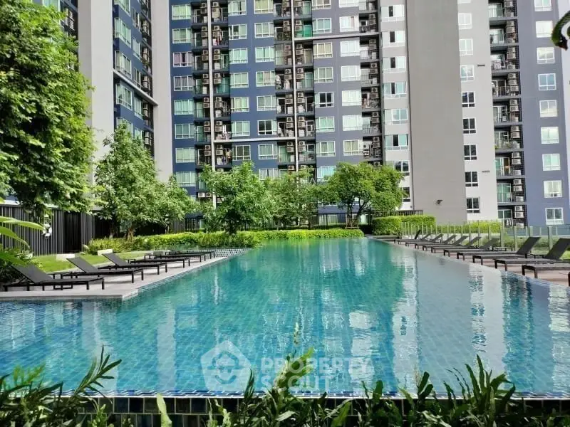 Luxurious apartment complex with a stunning outdoor pool and lush greenery.