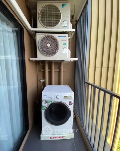 Compact balcony with washing machine and air conditioning units in modern apartment.