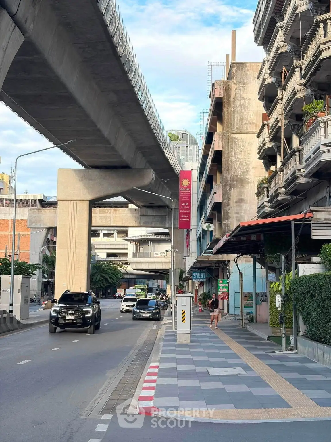 Urban street view with elevated train tracks and residential buildings